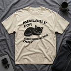 T-Shirt — 'AVAILABLE FOR EMERGENCIES ONLY' Tired Cat Graphic Tee (Tired jokes)